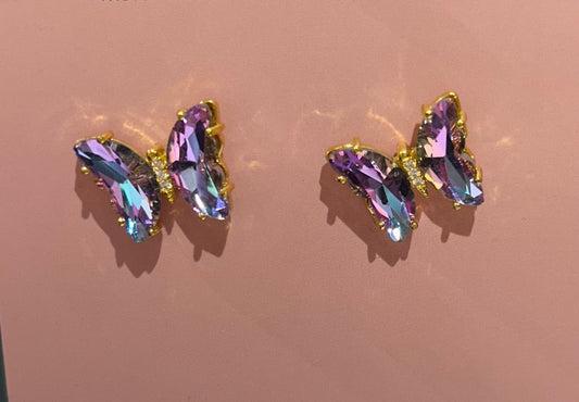Pair of earrings with multicolored gemstones on a pink background